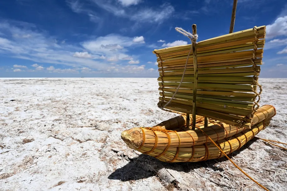 replica of a boat known as a totora boat is pictured on a desert Poopo lake Bolivia